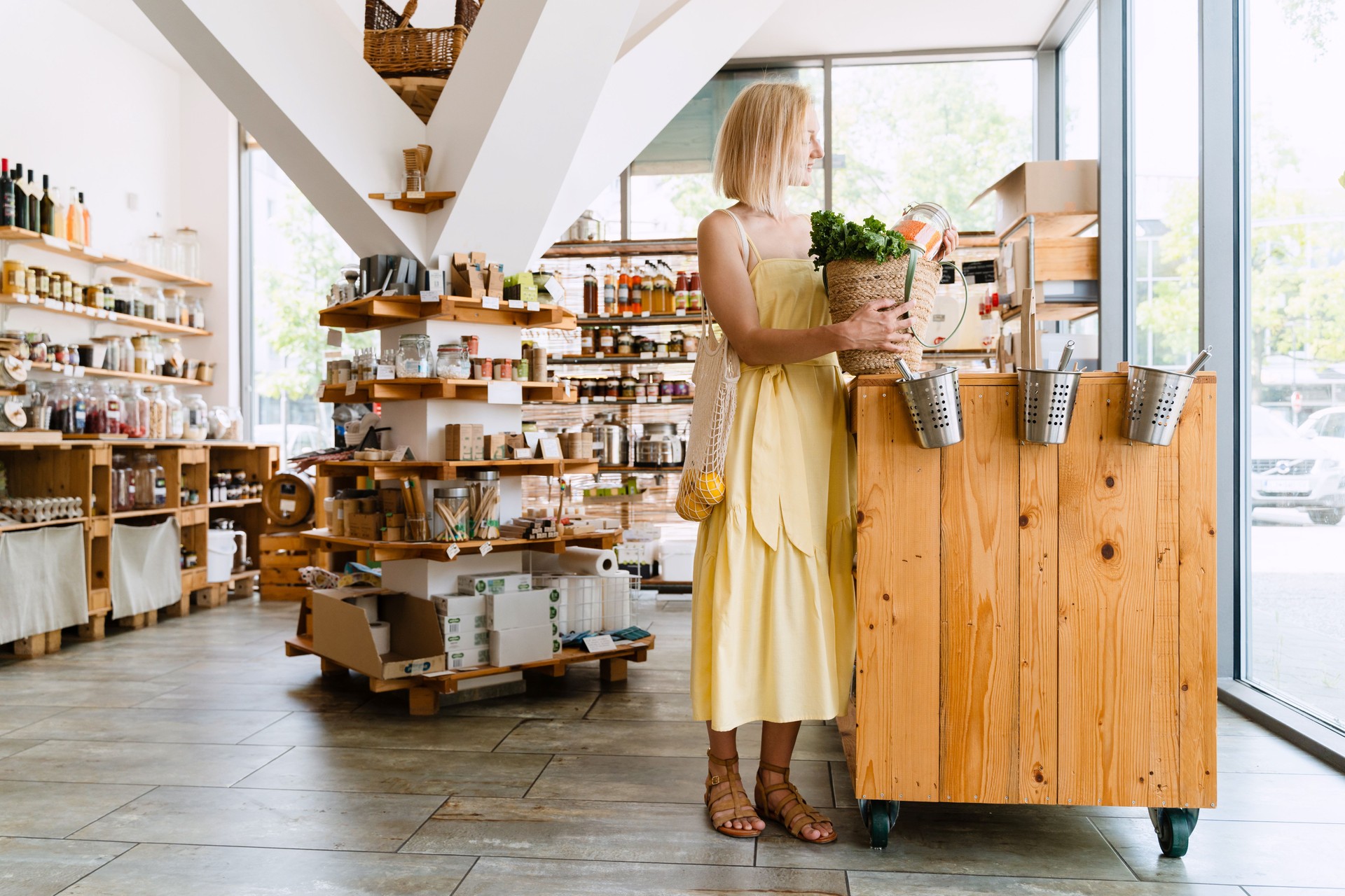 Smiling woman buying organic food and eco products in sustainable plastic free store. Happy female customer shopping at local grocery shop.